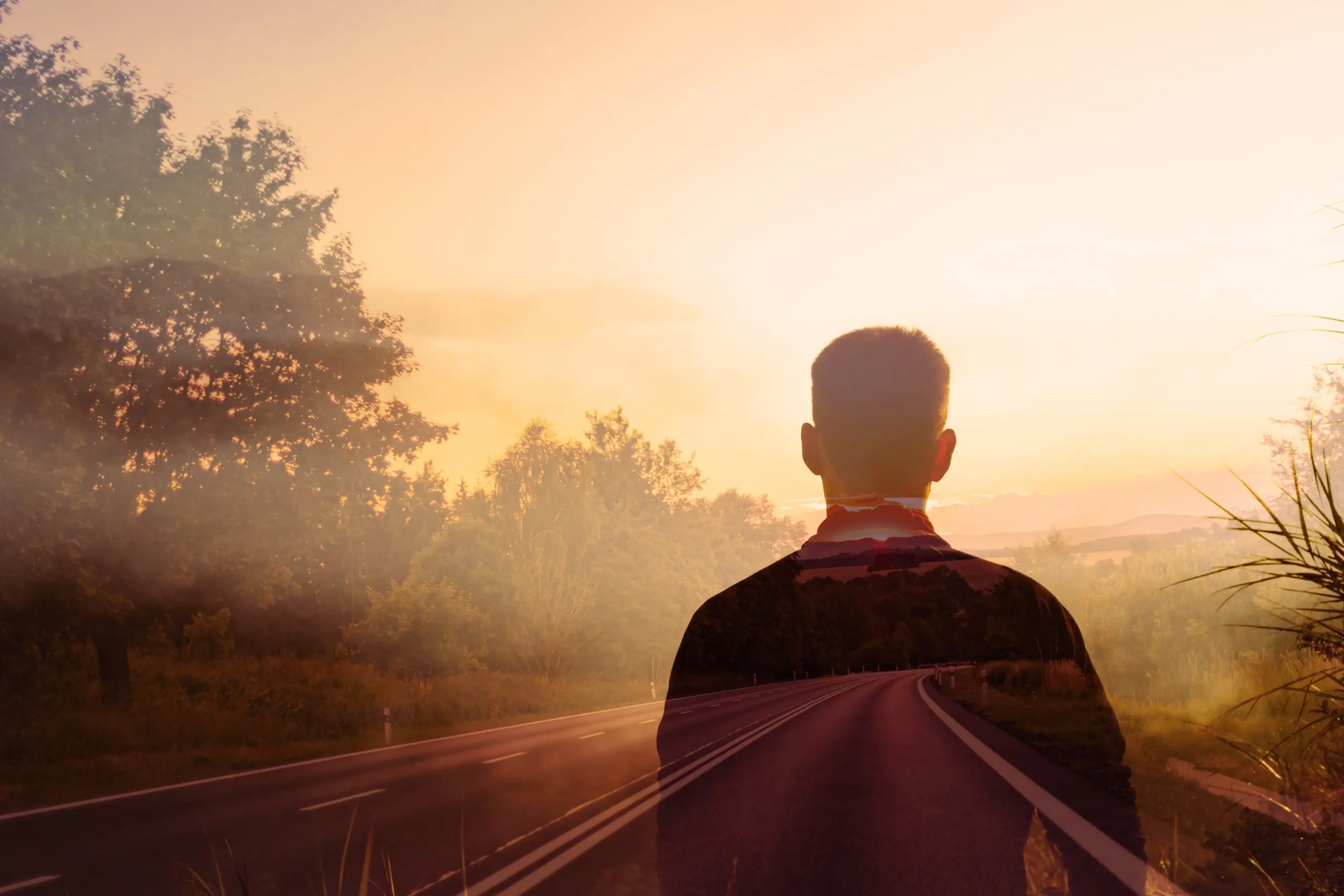 Man alone looking down a foggy country road path. Looking to the future concept.
