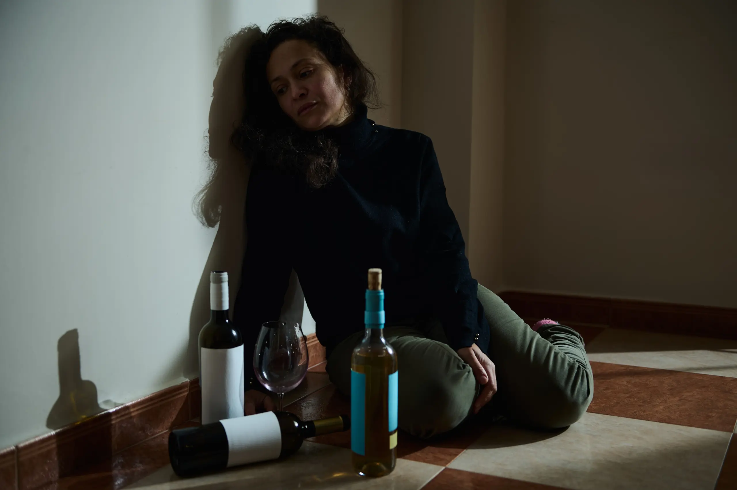 soft lighting, conveying emotional struggle rather than active drinking.