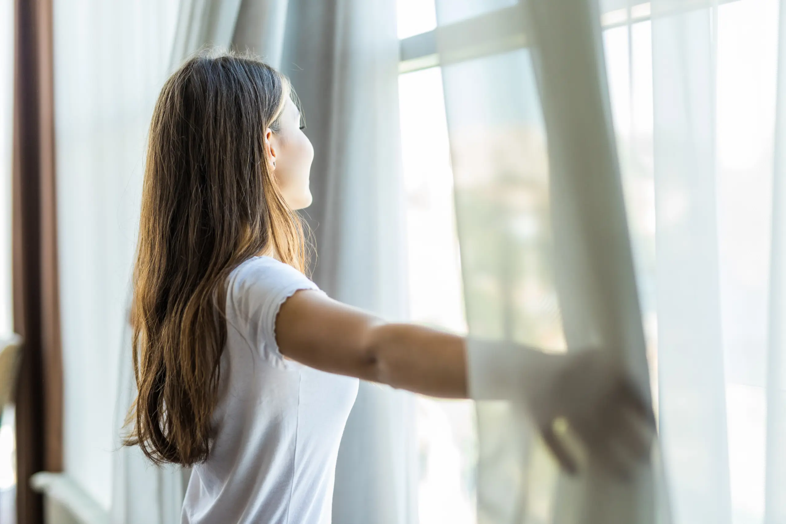 Person practicing mindful breathing in a calm, light-filled space