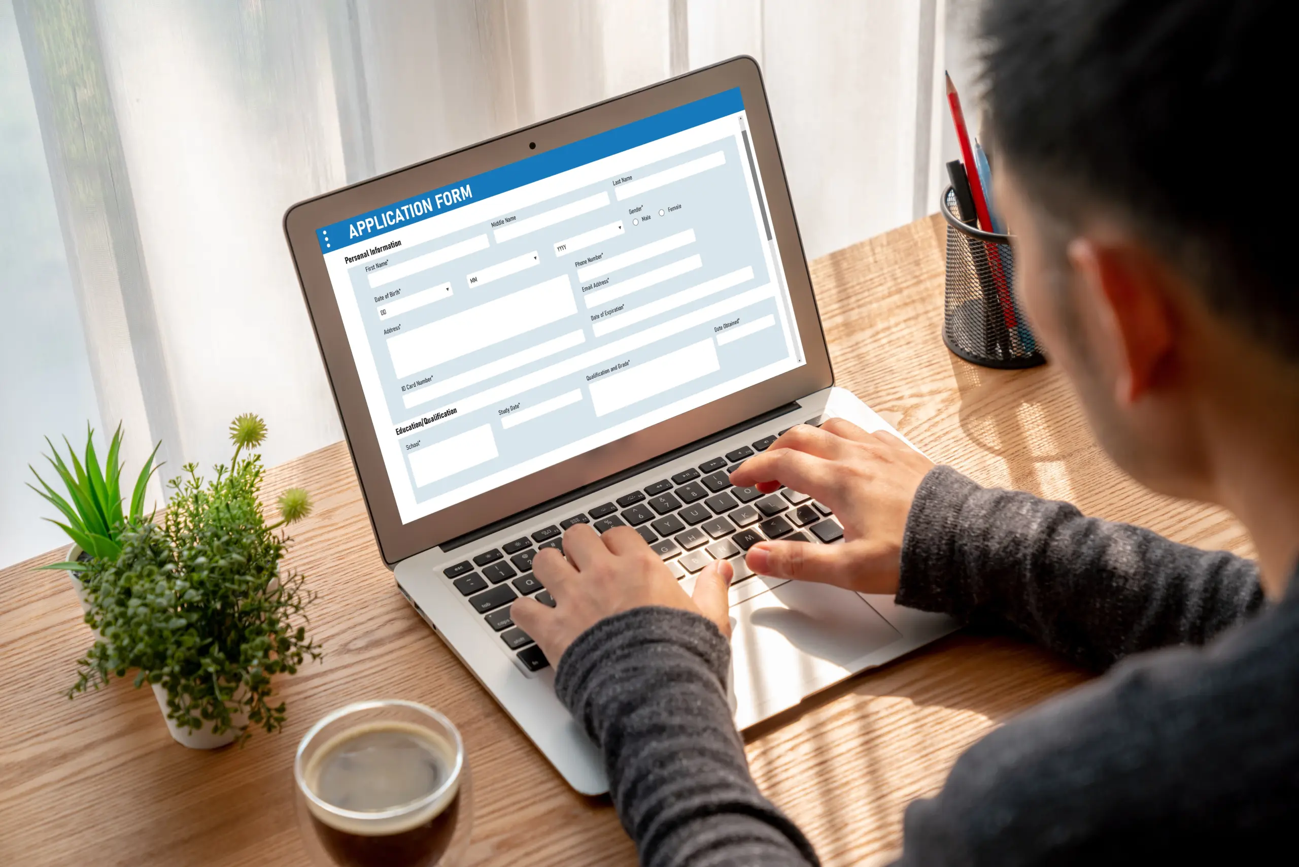 Person filling out FAFSA or scholarship application on a laptop.